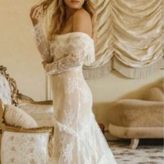 a woman in a white wedding dress posing for a photo with her hand on her hip