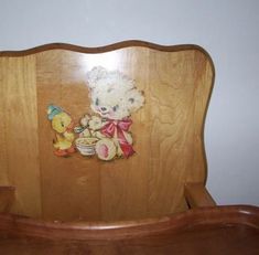 a wooden rocking chair with a teddy bear on it