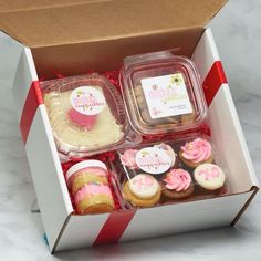 an open box with cupcakes and cookies in it