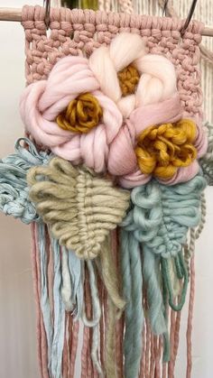 a close up of a piece of cloth hanging on a wall with flowers in it