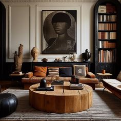 a living room filled with furniture and bookshelves next to a painting on the wall