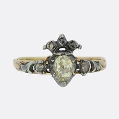 Here we have a delightful antique diamond ring dating back to the Georgian period. A single oval shaped yellow tinted rose cut diamond has been cut-collet set at the centre and surmounted with a rose cut diamond set crown. This focal motif is then flanked on either side by a single additional rose cut diamond at either shoulder. All stones here are set in silver with closed back settings whilst the piece is finished with a flora-like engraved band.  Condition: Used (Very Good) Weight: 1.9 grams Size: N (54) Band Width: 1mm Centre Diamond Dimensions: 5mm x 3.5mm (approx. 0.20ct) Remaining Diamond Dimensions: 1 (2mm), 4 (1mm) Tested As: Gold and Silver Box: Vintage Ring Box Shipping Policy We dispatch all items via a secure, trackable and signed for delivery service providing full insurance Diamond Crown Ring, Diamond Star Necklace, Georgian Era, Diamond Crown, Antique Diamond Rings, Crown Ring, Statement Ring Silver, Silver Tops, Diamond Star