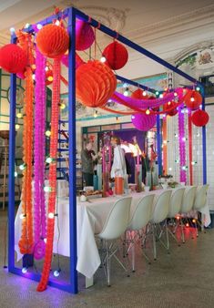 a room with tables, chairs and decorations on the table is decorated in bright colors