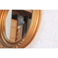 a gold framed mirror hanging on the wall