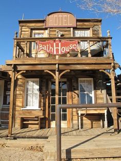 an old wooden building with a sign that says bath house on the front and side