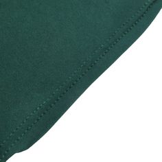 the back side of a dark green shirt with white stitching on it's chest