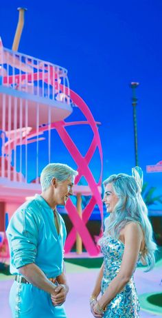 a man and woman standing next to each other in front of a pink spiral staircase