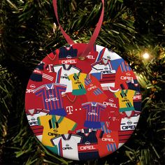 a christmas ornament hanging from a tree with soccer jerseys on it's side