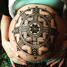 a pregnant woman's belly with an intricate tattoo design on her stomach and the words live lotus henna written below it