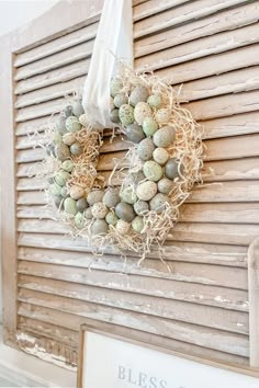 an easter wreath hanging on the side of a building with eggs in it and burlocks