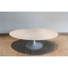 an oval marble table on a wooden floor