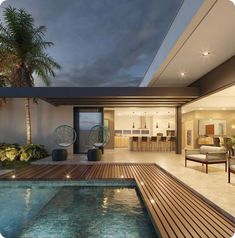 an indoor swimming pool with wooden decking and seating area next to the living room