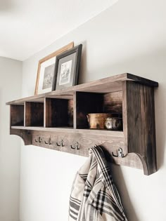 a wooden shelf with hooks and pictures on it