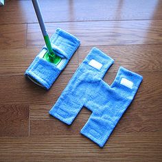 a mop is laying on the floor next to two blue towels with holes in them