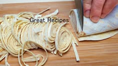 a person is cutting up some food on a wooden table