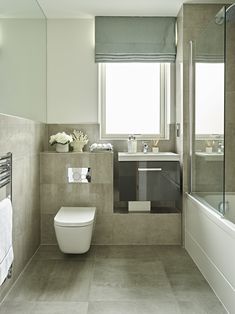 a bathroom with a toilet, sink and bathtub next to a window in it