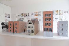 several models of houses are displayed on a shelf