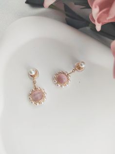 A pair of 14K gold cute and nicely freshwater pearls with pink crystal drop clip on earrings. Lightweight invisible clip on earrings for non pierced ears and sensitive ears. Materials: 14K Gold, Copper, Pink Crystal, Pearl  Size: 1.4in/3.5cm Style: Minimalist 100% Handmade Jewelry Perfect gift for friends/girlfriend/wife and yourself They will arrive packaged in lovely jewellery bag. Please mark as a gift when you need gift box packaging About me and the shop: As the owner of this little shop, I Delicate Pink Pearl Earrings As Gift, Pink Pearl Earrings For Gift, Dainty Pink Pearl Drop Earrings, Pink Dainty Dangle Pearl Earrings, Pink Clip-on Earrings For Wedding, Pearl Clip-on Jewelry Gift, Pink Pearl Earrings For Pierced Ears, Pink Round Pearl Earrings For Pierced Ears, Delicate Pink Pearl Earrings For Gift