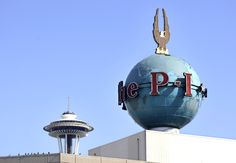 a large sign on top of a building with a tower in the backgroud