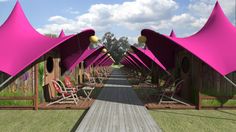 a row of pink tents sitting next to each other on top of a grass covered field