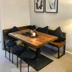 a wooden table sitting next to two black chairs