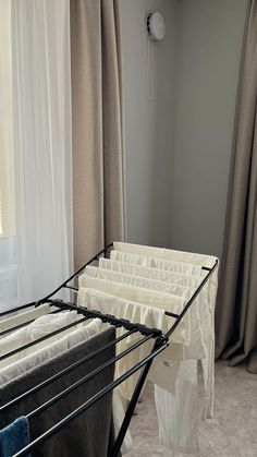 there is a metal bed frame in the room with curtains on the window sill