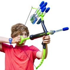 a young boy holding up a green bow and arrow with blue arrows attached to it