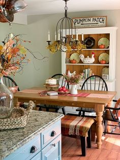 a dining room table and chairs in front of a hutch filled with pumpkins