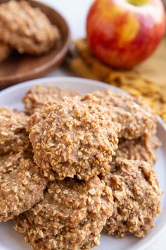 several cookies on a plate with an apple in the background