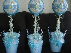 three blue vases with balloons and streamers in them sitting on a black couch