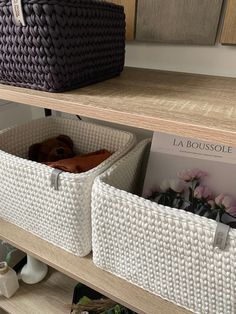 two wicker baskets sitting on top of a wooden shelf