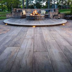 an outdoor fire pit surrounded by wooden decking