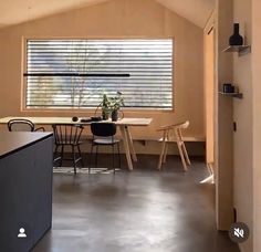 an open kitchen and dining room area in a small space with large windows on the wall