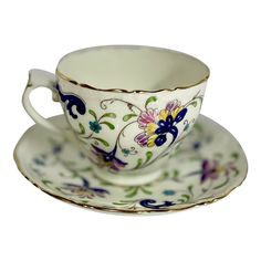 an ornate tea cup and saucer on a white background