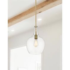 a light fixture hanging from the ceiling in a room with white walls and wood beams