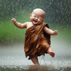 a laughing baby in the rain wearing a brown robe and holding an umbrella over his head