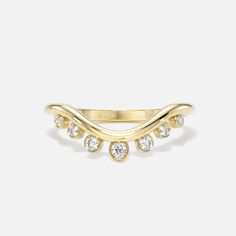 a yellow gold ring with three diamonds on the bottom and two rows of white stones in the middle