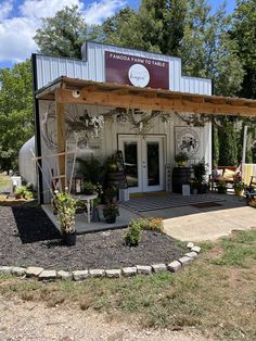 a small building with lots of potted plants in front of it