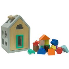 a wooden toy house next to colorful blocks