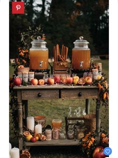 an old wooden table topped with jars filled with apples and cinnamons next to candles