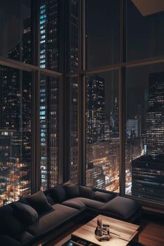 a living room filled with lots of furniture and tall buildings in the background at night