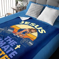 a bed with a blue comforter that has jesus on it and an image of a woman holding a barbell