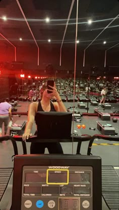 a woman sitting in front of a laptop computer on top of a table next to a machine