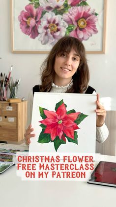 a woman holding up a sign that says christmas flower free master class on my patron