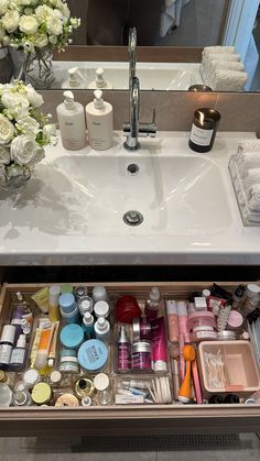 a bathroom sink filled with lots of beauty products