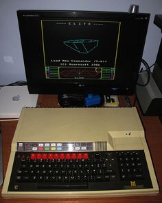 an old computer sitting on top of a wooden desk next to a keyboard and mouse