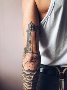 a man with a lighthouse tattoo on his arm