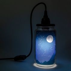 a glass jar with a night sky in it and a light plugged into the side