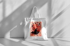 a white tote bag with an image of a cat on it and birds flying around