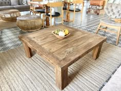 a wooden table sitting on top of a rug in a room filled with chairs and tables